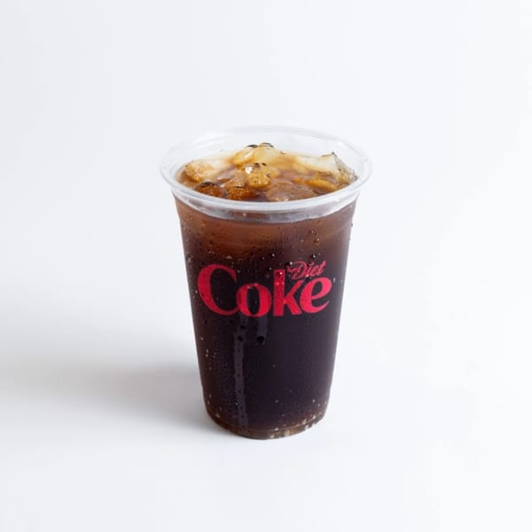 A plastic cup of Diet Coke with ice, condensation on the side, against a white background.